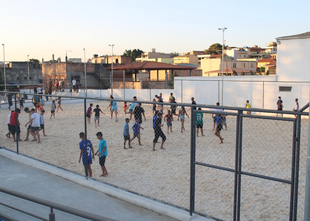 Jovens jogando futebol na quadra de areia